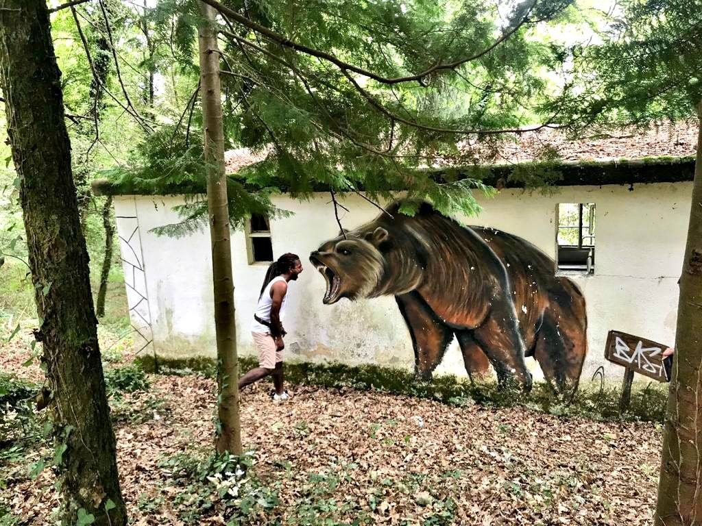 Un visitante da India co mural do oso, nas proximidades do Miño | Guido Álvarez Parga